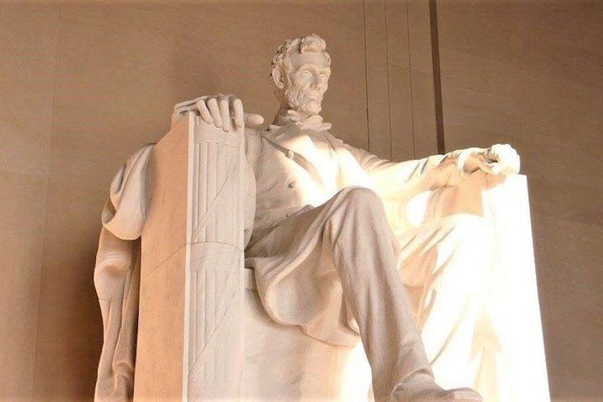 A marble statue of a seated figure with a draped cloth. 4