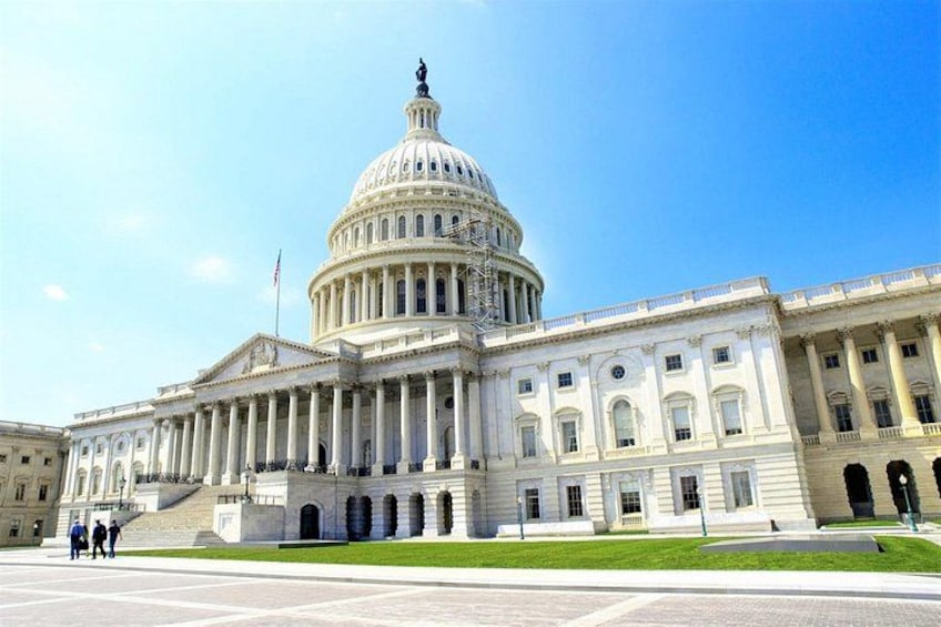 A large, white, neoclassical building with a prominent dome, columns, and a flagpole. 4