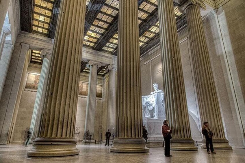 A grand interior with tall columns, a skylight, and a statue. 2