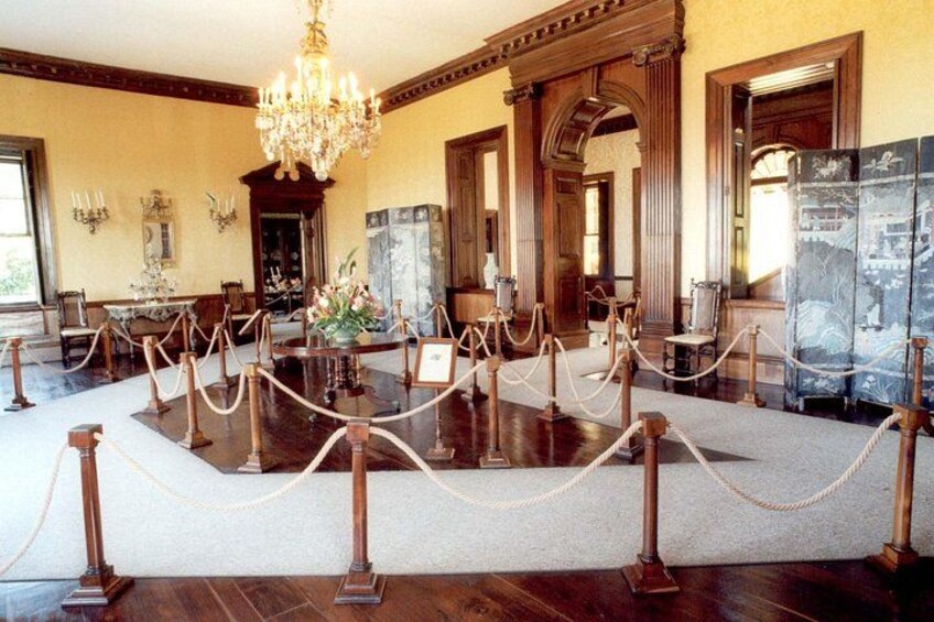 A room with a chandelier, wooden furniture, and a glass display case. 2