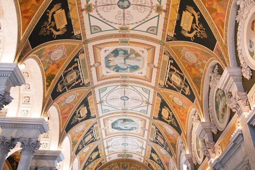 An ornate ceiling with intricate frescoes and architectural details. 4