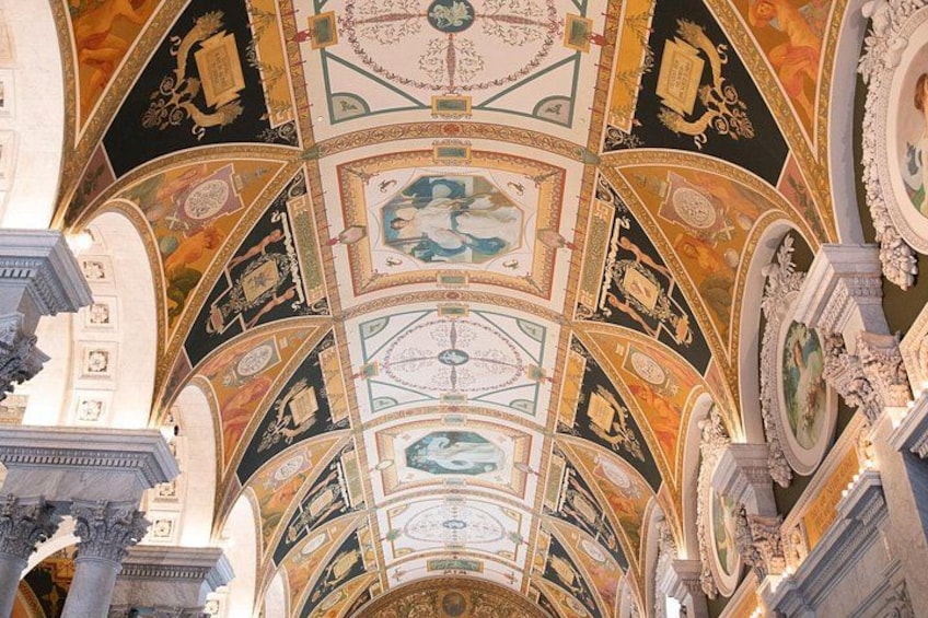 A grand hall with ornate ceiling frescoes and classical architecture. 5