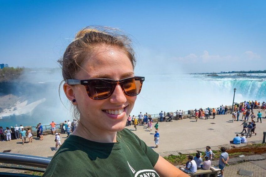 Une personne portant un t-shirt vert, avec une cascade en arrière-plan. 2