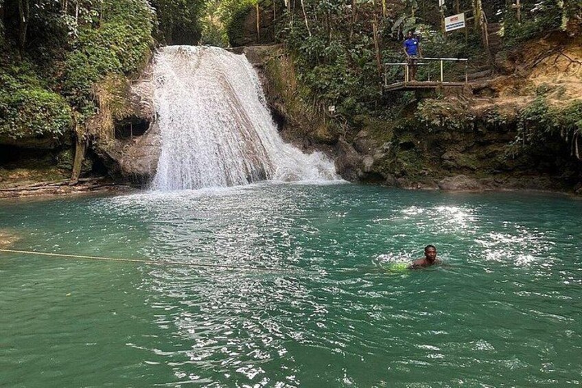 Une cascade, une personne qui nage et une falaise rocheuse. 4
