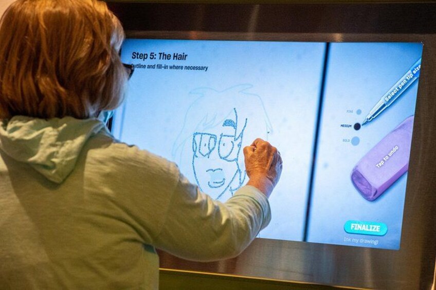 Iemand schetst een stripfiguur op een digitaal scherm met een stylus. 3