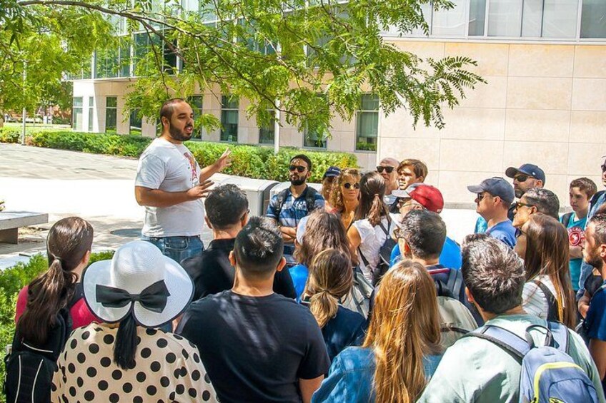 A group of people gathered outdoors, listening to a speaker. 2