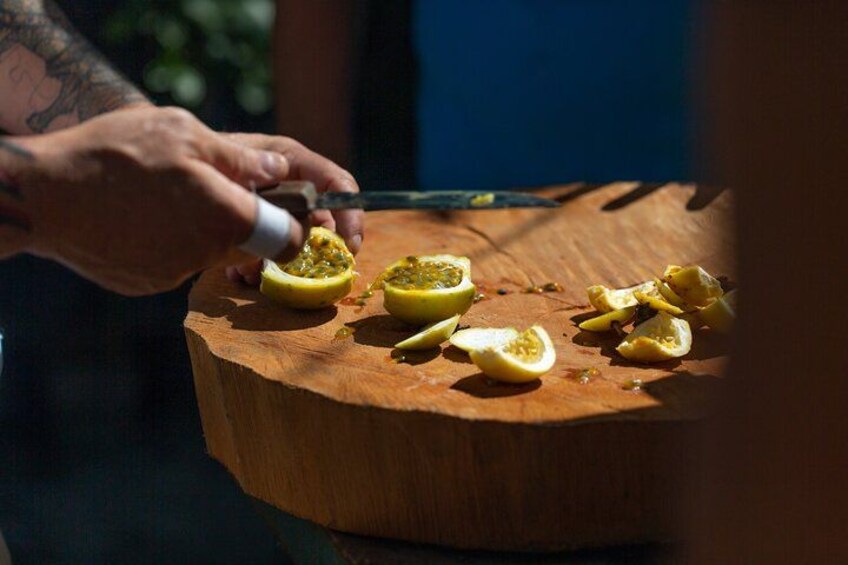 A person cutting a fruit on a wooden board. 3