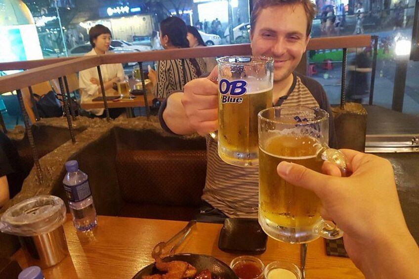 A person holding two glasses of beer with the logo 'OB Blue' on them. 3