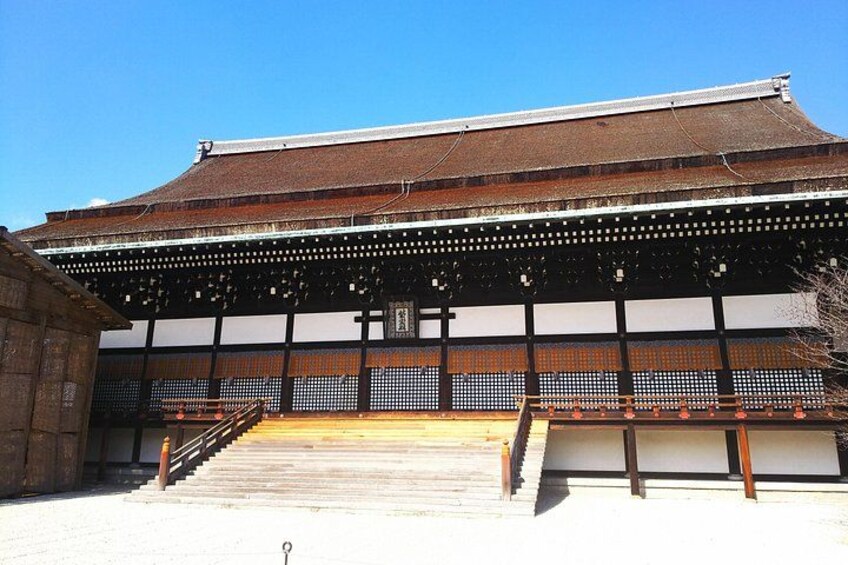 A traditional Japanese building with a tiled roof, wooden lattice structure, and a staircase leading to the entrance. 2