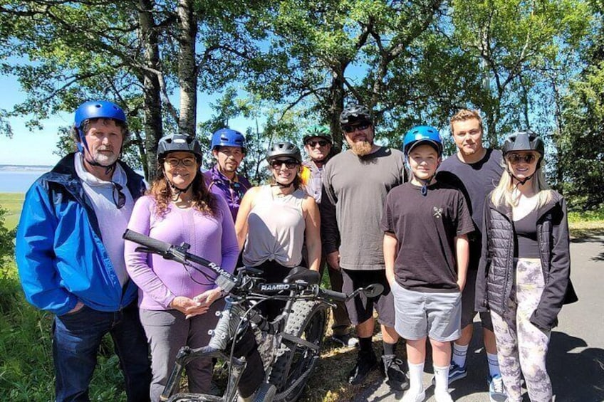 En gruppe mennesker med cykler i en park. 3
