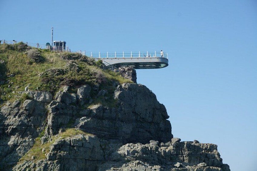 A rock formation with a viewing platform extending over a cliff. 3