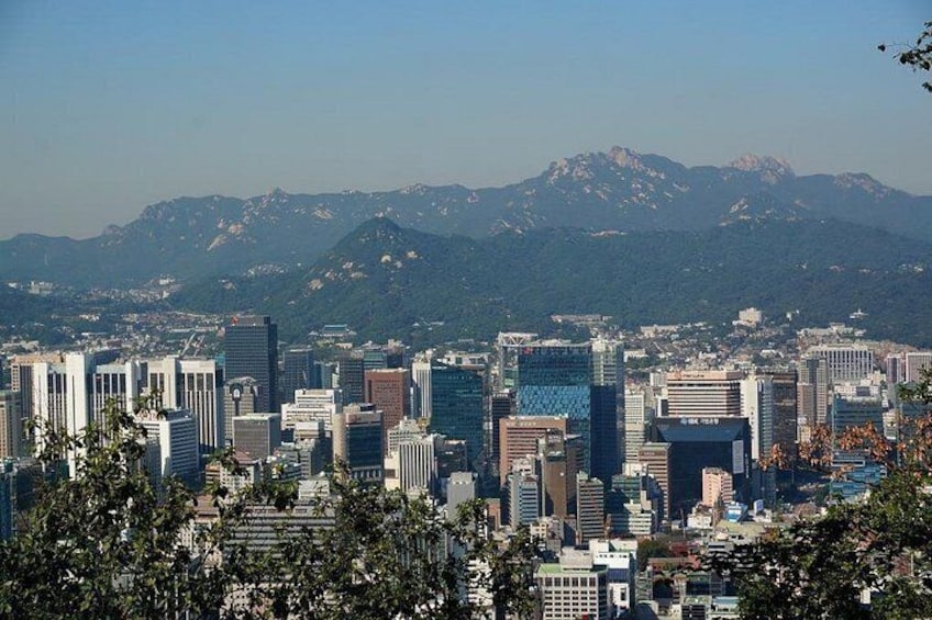 Un horizonte urbano con edificios modernos y una cordillera al fondo. 1