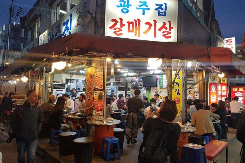 Un vivace mercato di street food di notte, con persone che cenano e passeggiano. 3