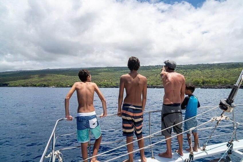 Three individuals on a boat, a body of water, and a distant shoreline. 2