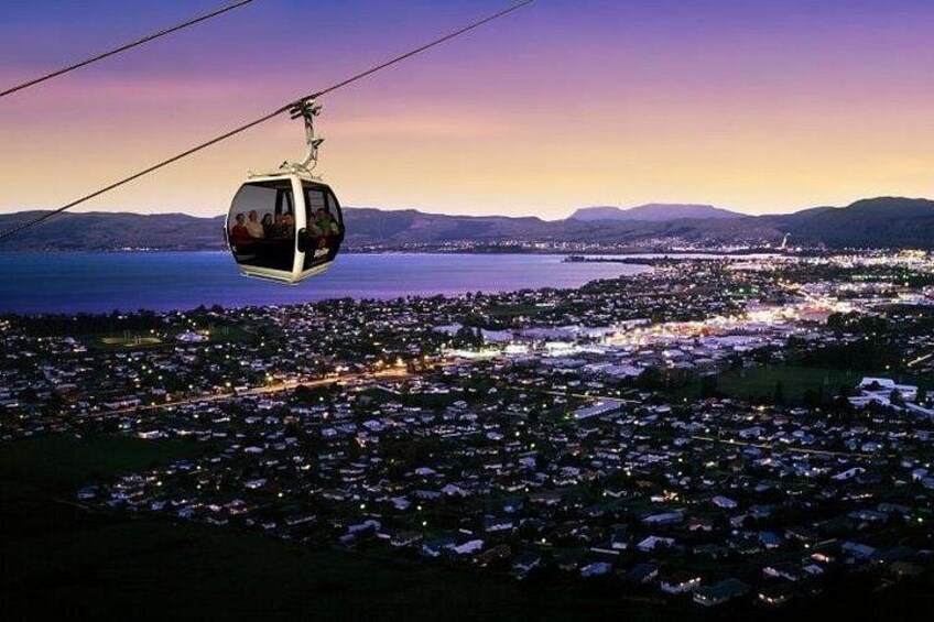A cable car over a coastal city at dusk. 2
