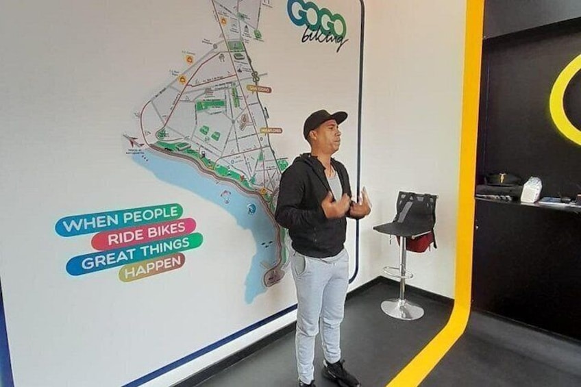 A man standing in front of a wall with a map and the text 'When people ride bikes great things happen.' 2