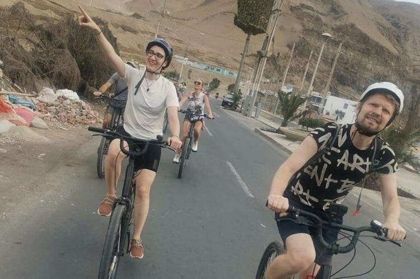 Two cyclists on a road with mountains in the background. 3