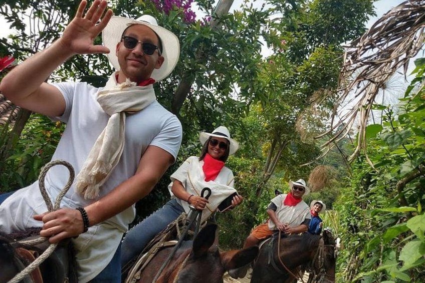 People riding horses in a lush, green forested area. 1