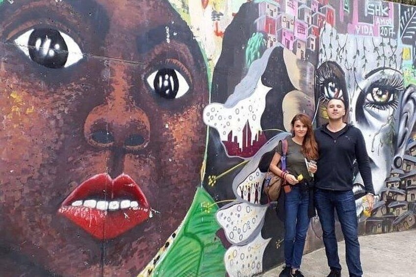 A mural with a large face, a dog, and a cityscape. 2