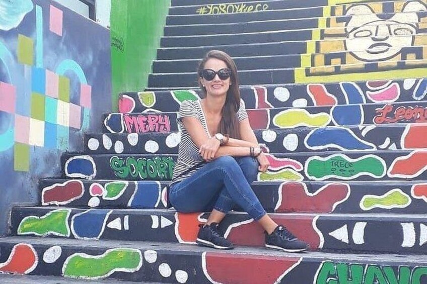 A person sitting on colorful graffiti-covered steps. 5