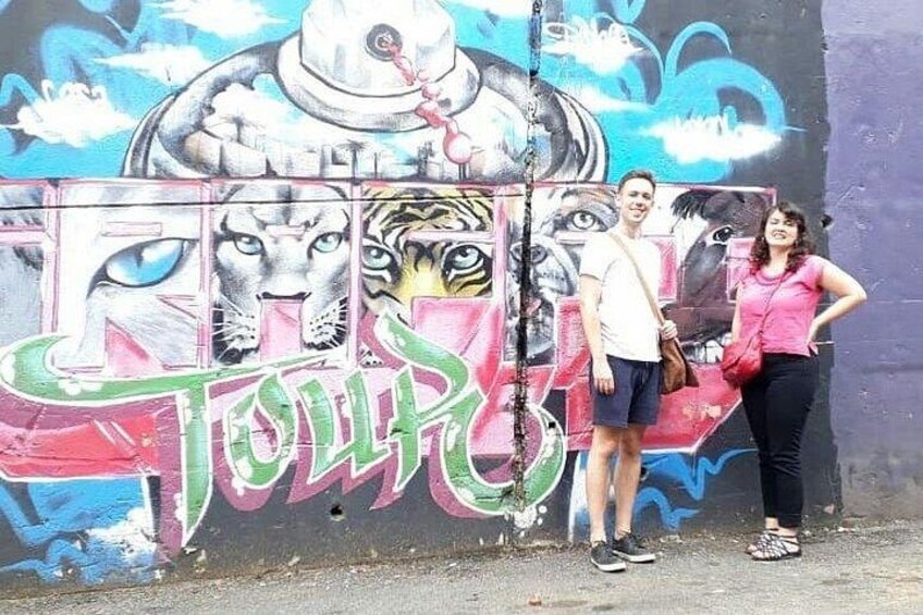 A graffiti wall with colorful artwork, including a tiger and a face. 3