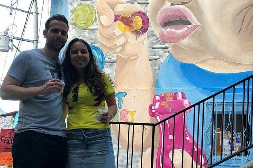 A couple standing in front of a large mural with a pink bear and a blue bear. 4