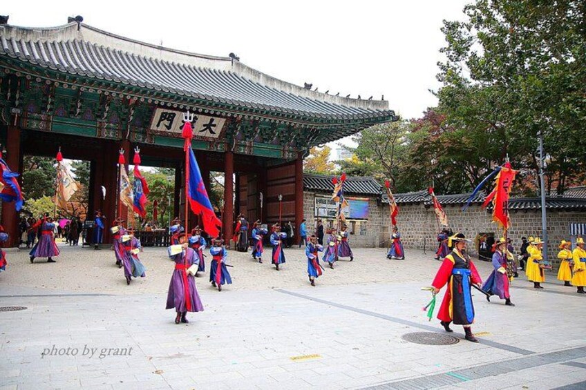 A traditional Korean dance performance in front of a historic gate. 2