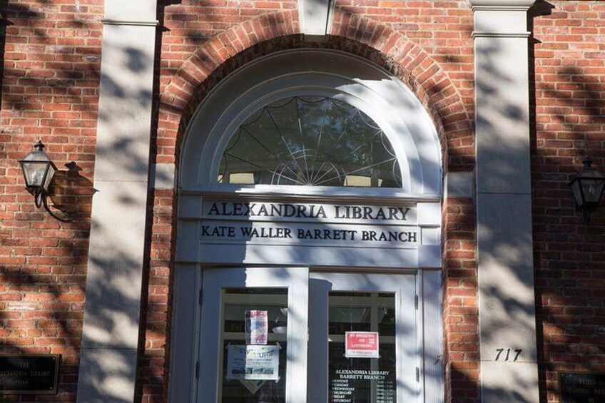 The exterior of the Alexandria Library, Kate Walker Barrett Branch, with a brick facade and arched entrance. 3