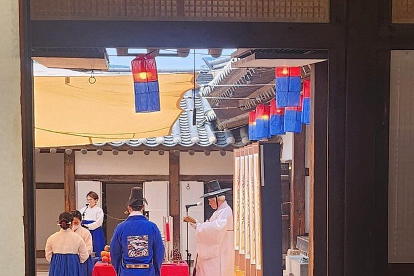Eingang eines traditionellen japanischen Gebäudes mit einem Ziegeldach, einem hängenden Laternen und einer Person in traditioneller Kleidung. 3