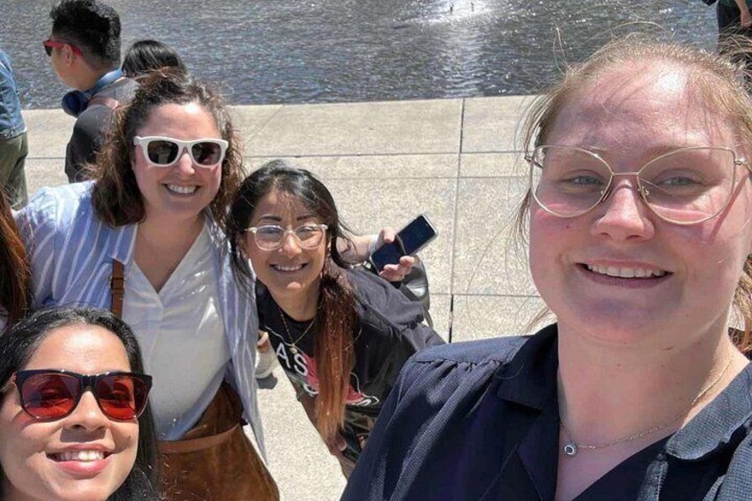 A group of people posing for a photo near a body of water. 1
