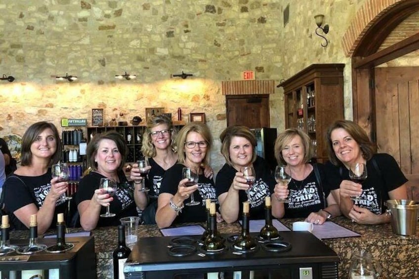 Un groupe de personnes trinquant avec des verres de vin dans un bar à l’ambiance rustique. 2