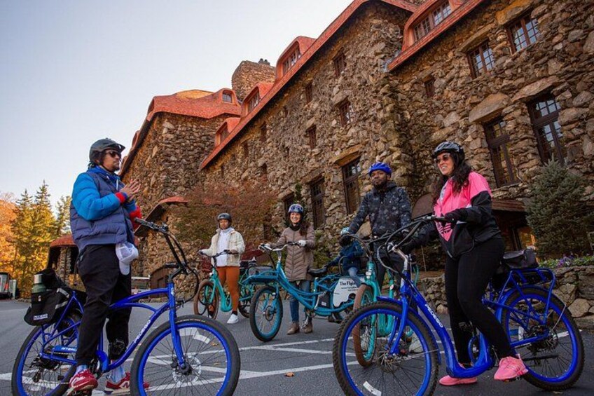 Un grupo de personas en bicicleta frente a un edificio de piedra. 3