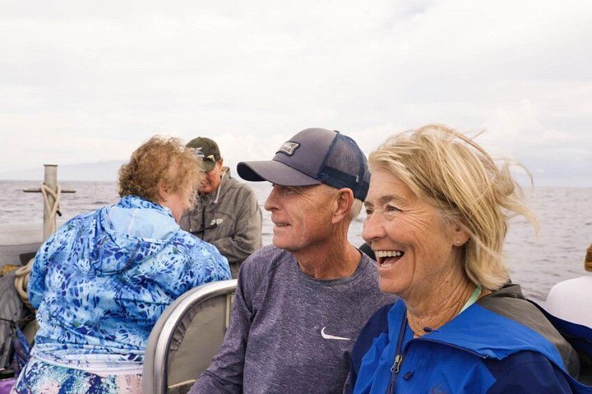 People on a boat with a body of water and a cloudy sky in the background. 3