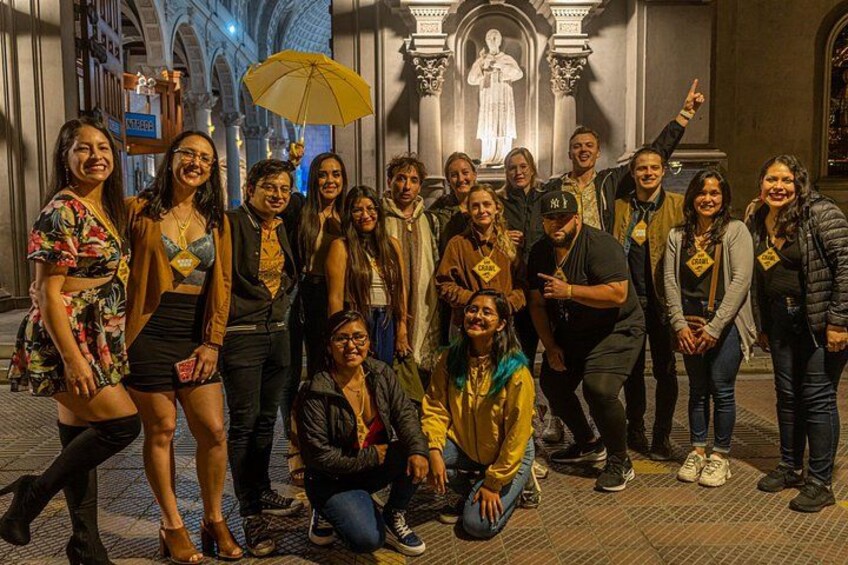 Un groupe de personnes posant devant un bâtiment historique orné d’arches et de statues. 2