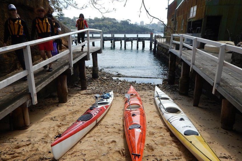 Une jetée en bois mène à un quai, et trois kayaks sont alignés sur le sable. 2