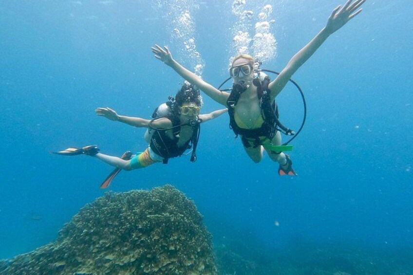 Dos buzos nadando bajo el agua con aletas y equipo de buceo. 5