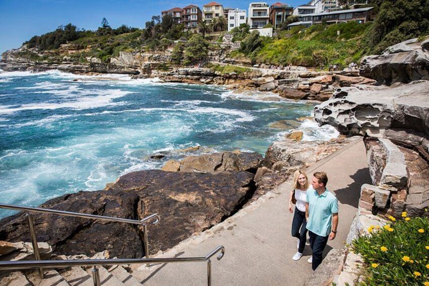 A coastal landscape with rocky cliffs, ocean waves, and residential buildings. 3