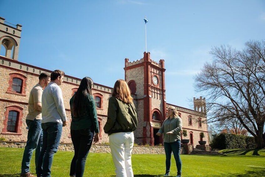 A group of people standing in front of a historic building with a clock tower. 3
