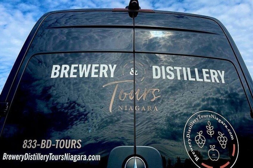 The rear of a vehicle with 'Brewery & Distillery Tours Niagara' and contact information. 2