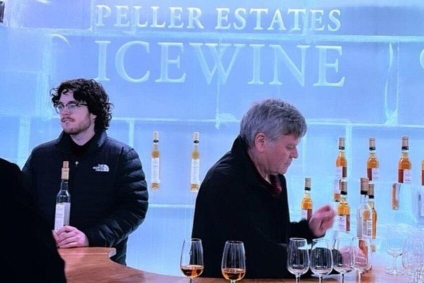 A wine tasting event with bottles and glasses on a table. 3