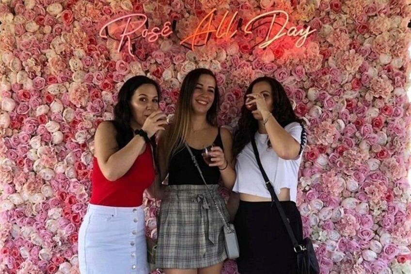 Three people standing in front of a floral backdrop with the text 'Rose All Day'. 4