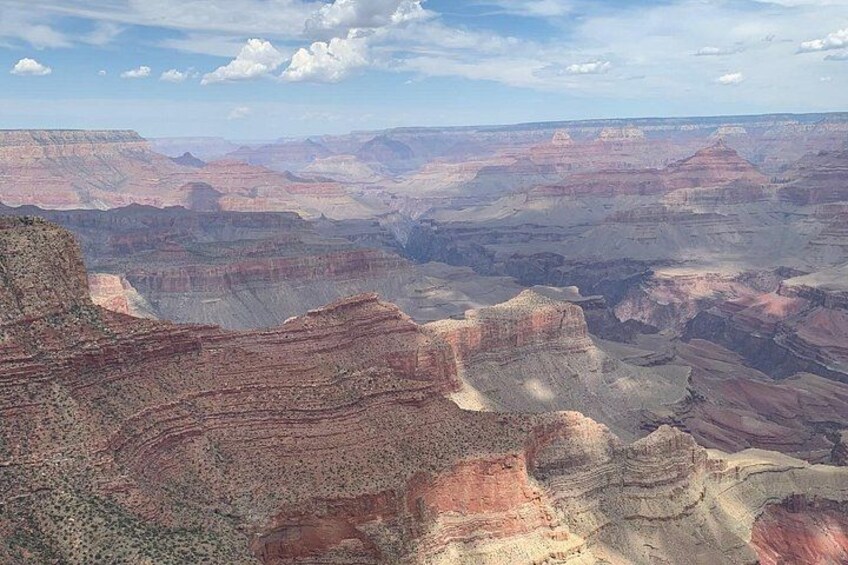 Un vaste paysage de canyon, avec des formations rocheuses en strates et un ciel dégagé. 4