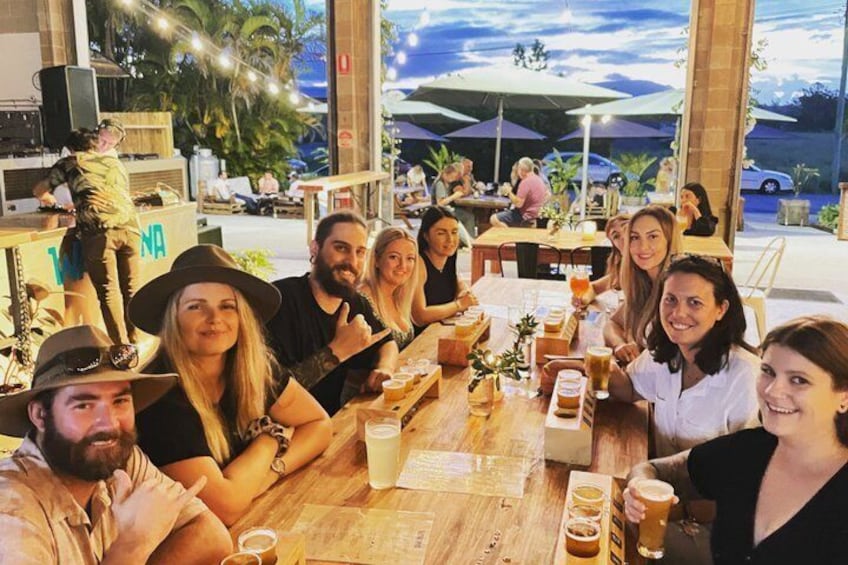 A group of people dining at an outdoor restaurant with tables and umbrellas. 4