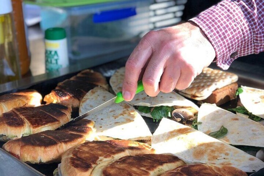 A person cutting a grilled sandwich. 2