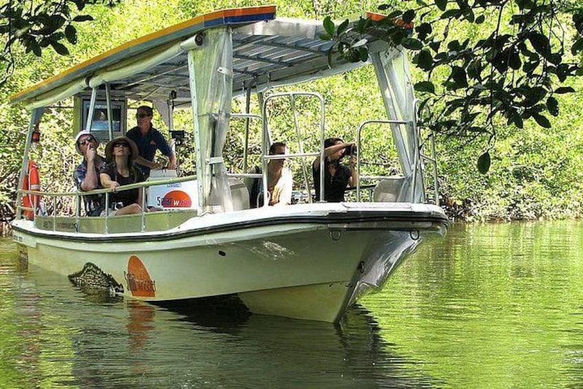 Un bateau transportant des passagers, entouré d’eau et de verdure. 3