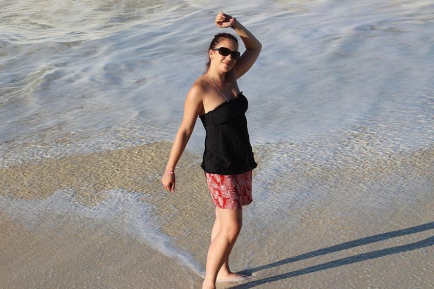 A person standing on a beach with waves in the background. 1
