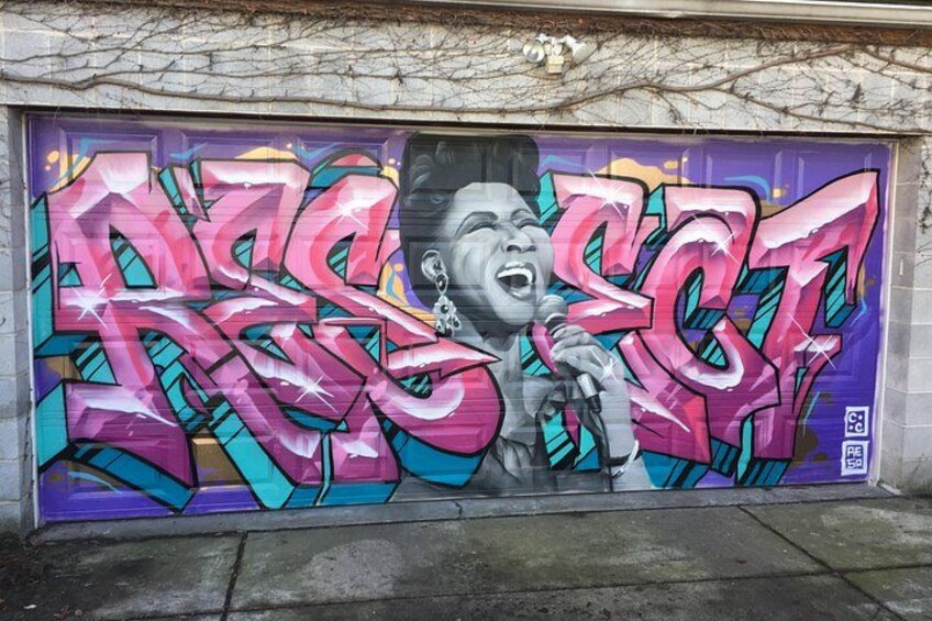 A graffiti mural with stylized text and a figure. 2