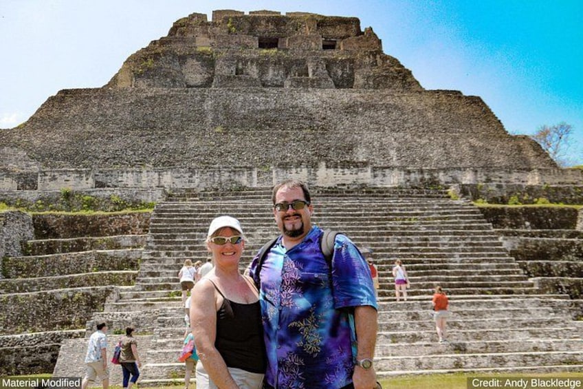 A large ancient pyramid with a staircase leading up to it, surrounded by tourists. 4