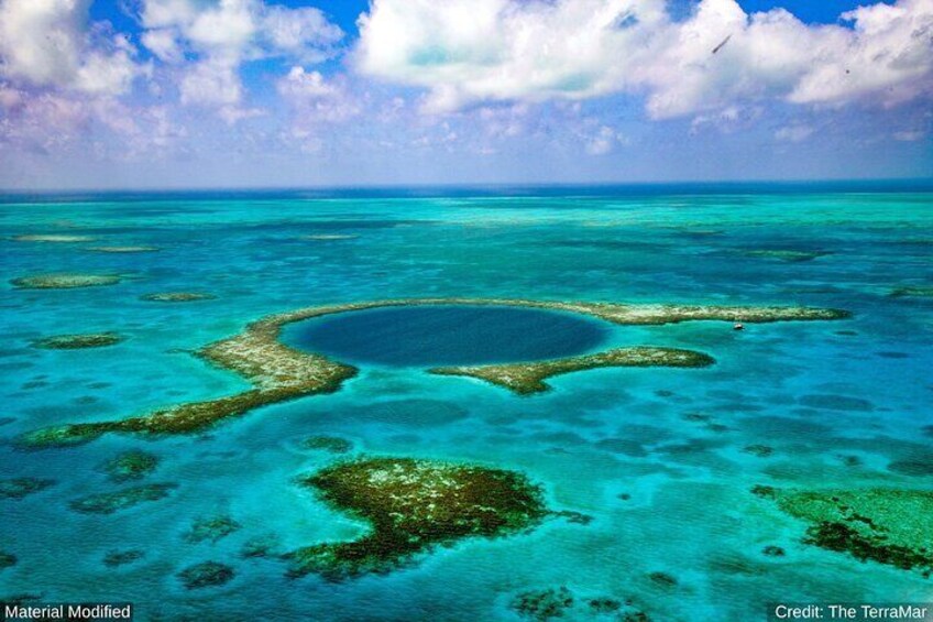 A clear blue sea with coral reefs and a large circular formation. 1