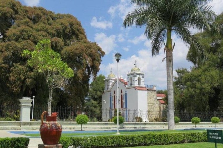 A church with a dome, surrounded by trees and a fountain. 3